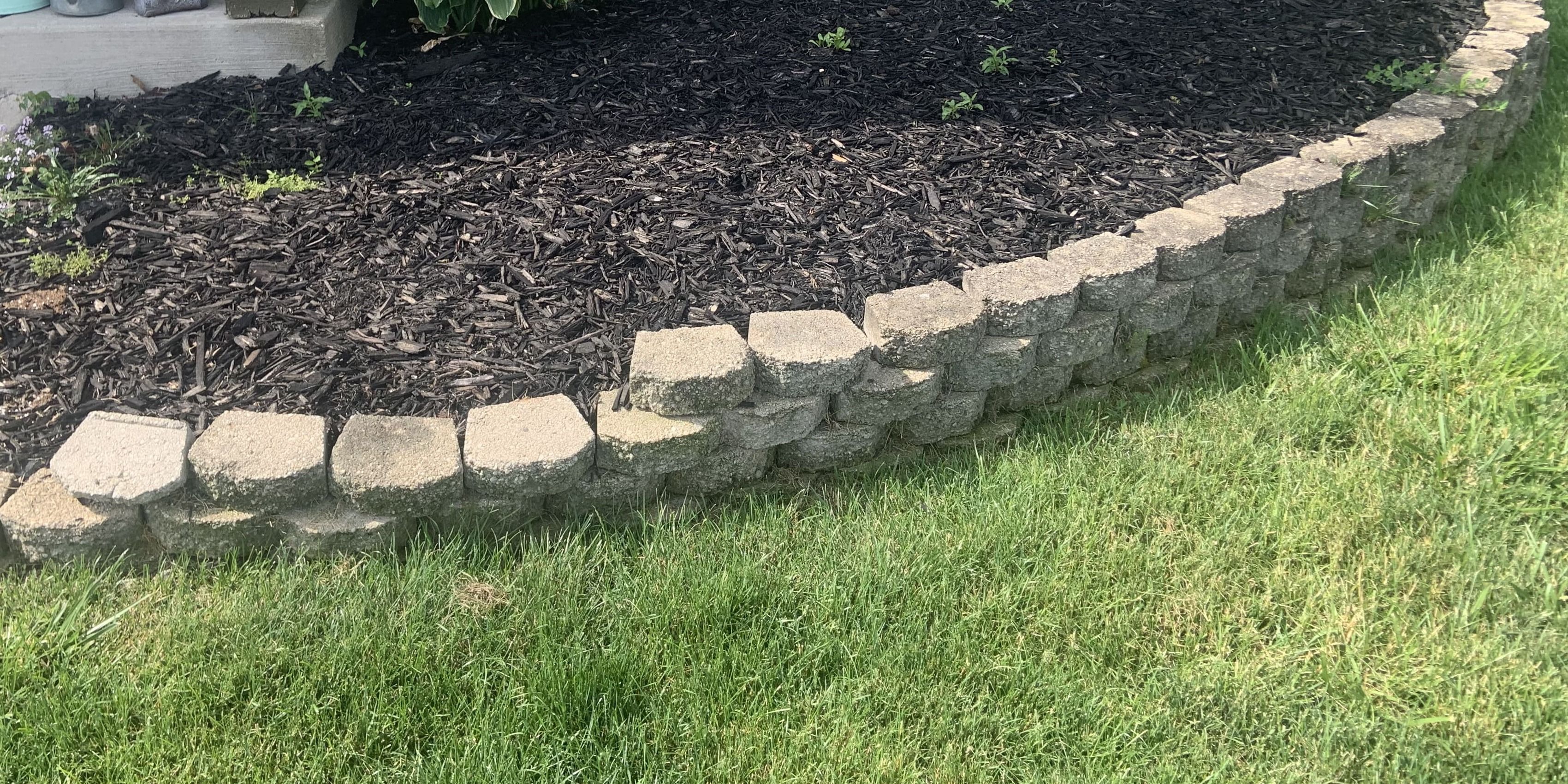 A stone retaining wall and mulch bed built by Oronoz Landscaping in Columbus, OH