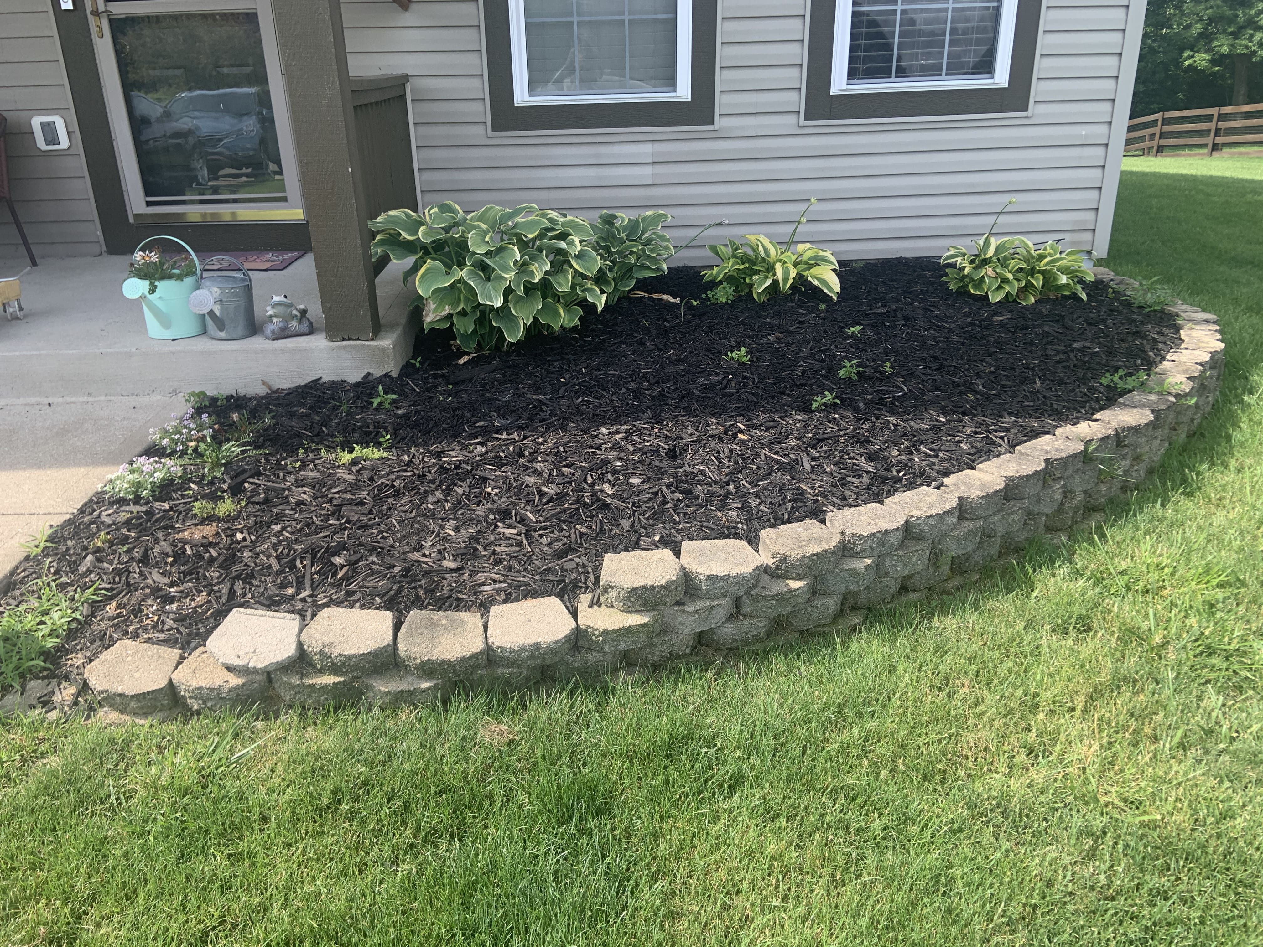 Curved natural-stone edging around a fresh mulch bed